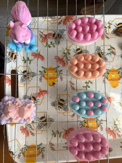 A selection of colorful molded soaps on a rack